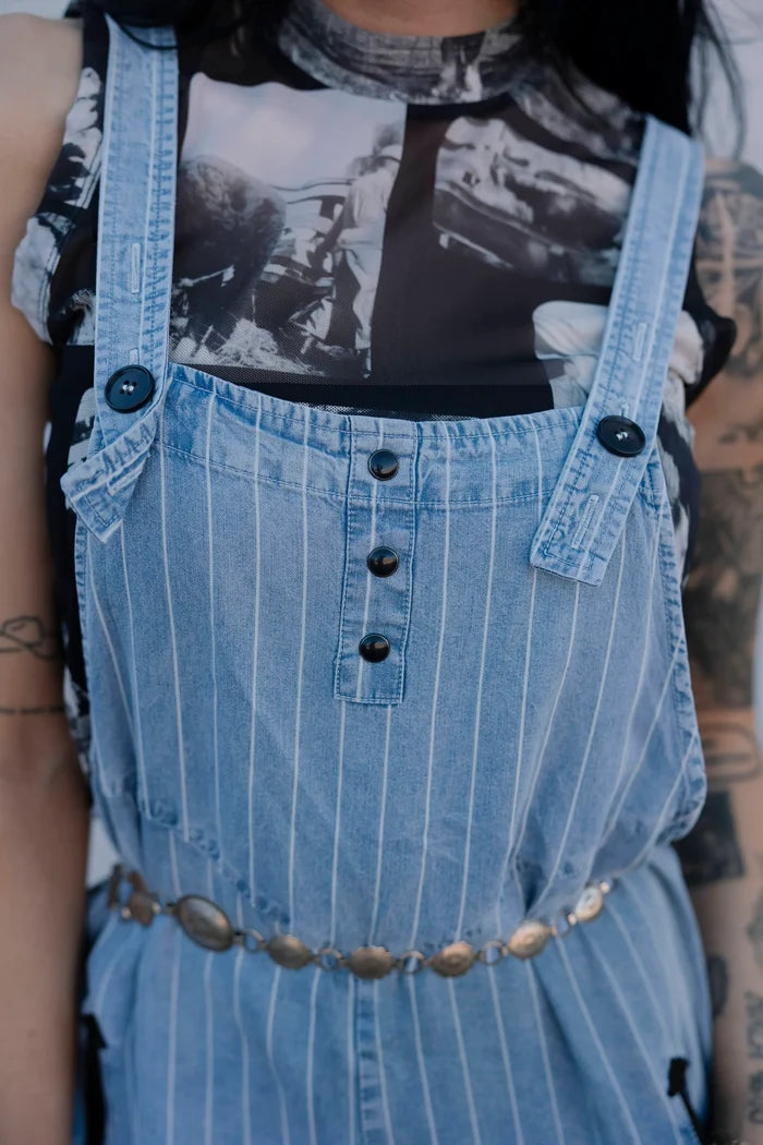 Light blue denim overalls, striped texture, dark button bib, adjustable shoulder straps