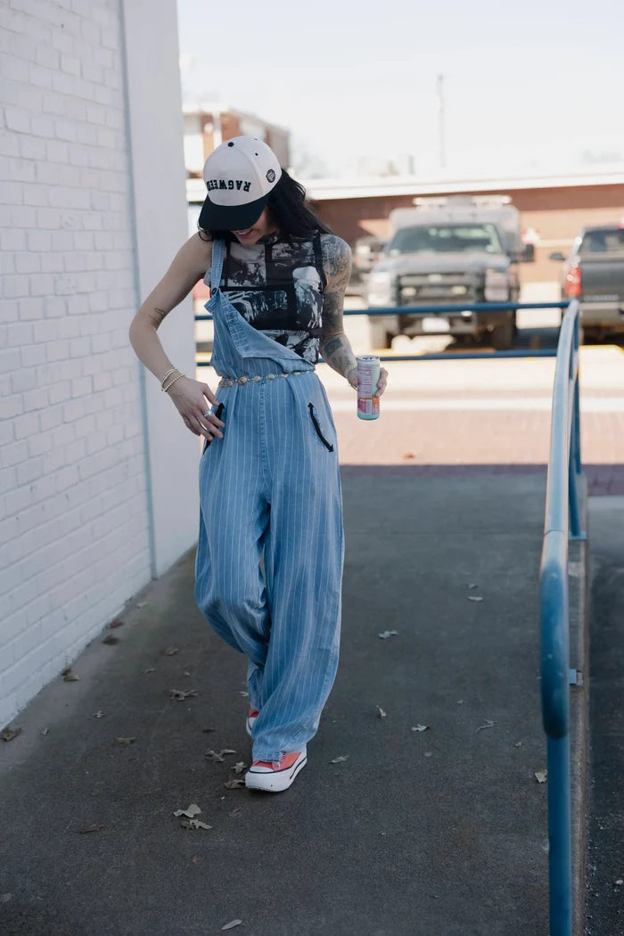 Light blue denim overalls with front bib and loose straight legs, adjustable straps