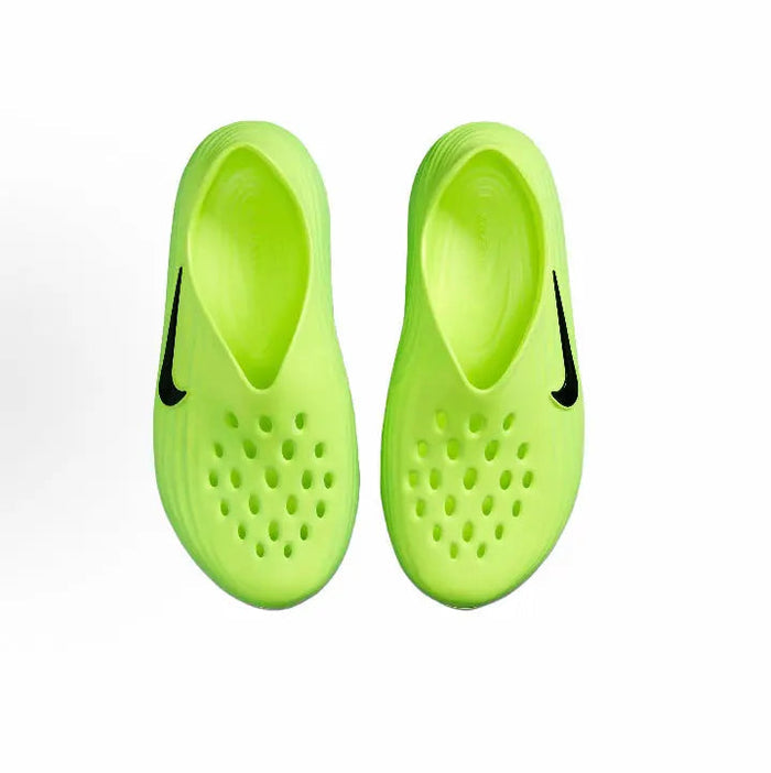 Pair of green slip-on sneakers with perforated toe and black Swoosh accents