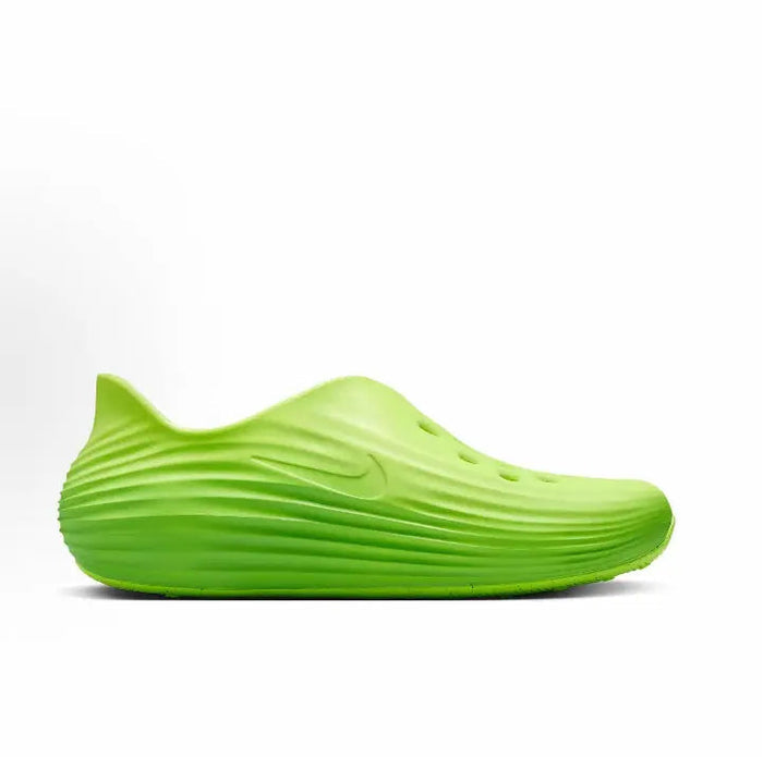 Green slip-on sneakers with wave-pattern midsole and small black Swoosh