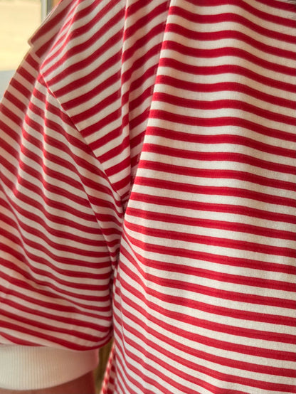 Red-and-white striped T-shirt fabric close-up, draped sleeve section