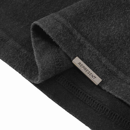 Black T-shirt cuff label with REPRESENT on inner hem seam