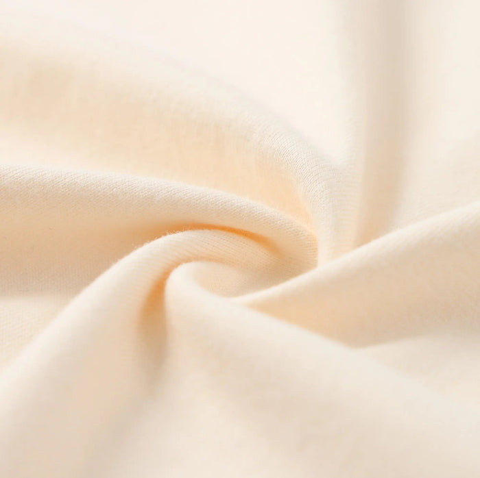 Cream T-shirt sleeve fabric close-up with soft knit texture