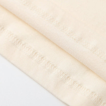 Cream T-shirt side seam and stitching detail close-up