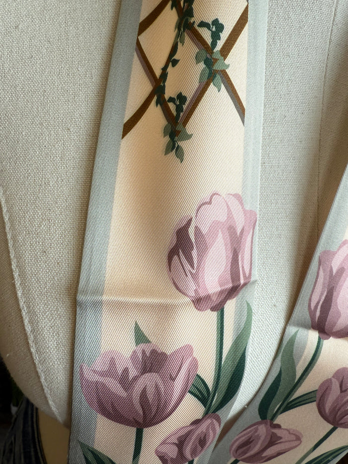 Close-up rose floral twilly scarf, pink roses and green leaves on light background