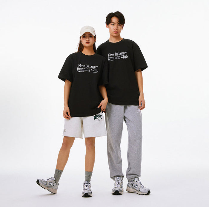 Pair of black New Balance Running Club T-shirts on two people
