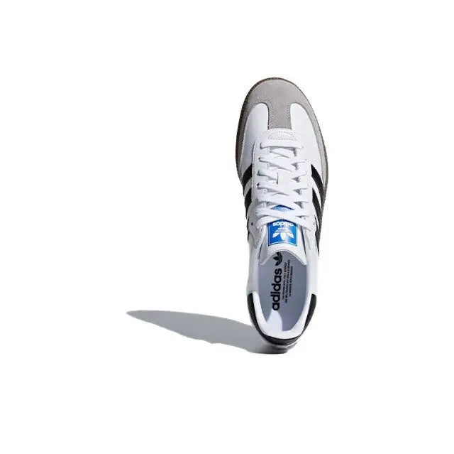 White low-top sneaker with laced front and brand text on the insole
