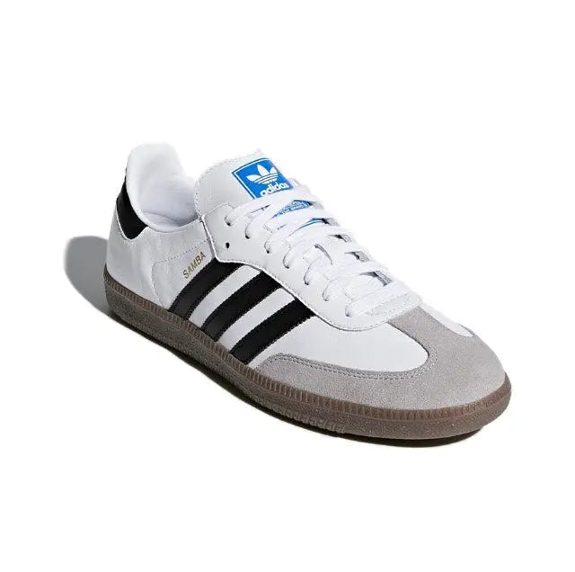 White and gray suede-style low-top sneakers with black stripes and blue tongue tag