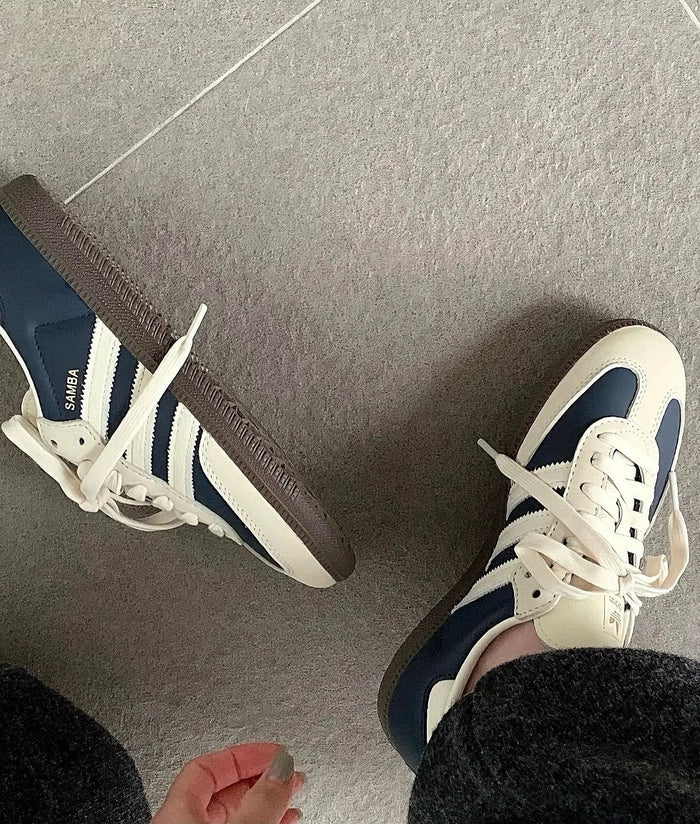 Adidas Samba OG sneakers on feet, white uppers with navy stripes and laces