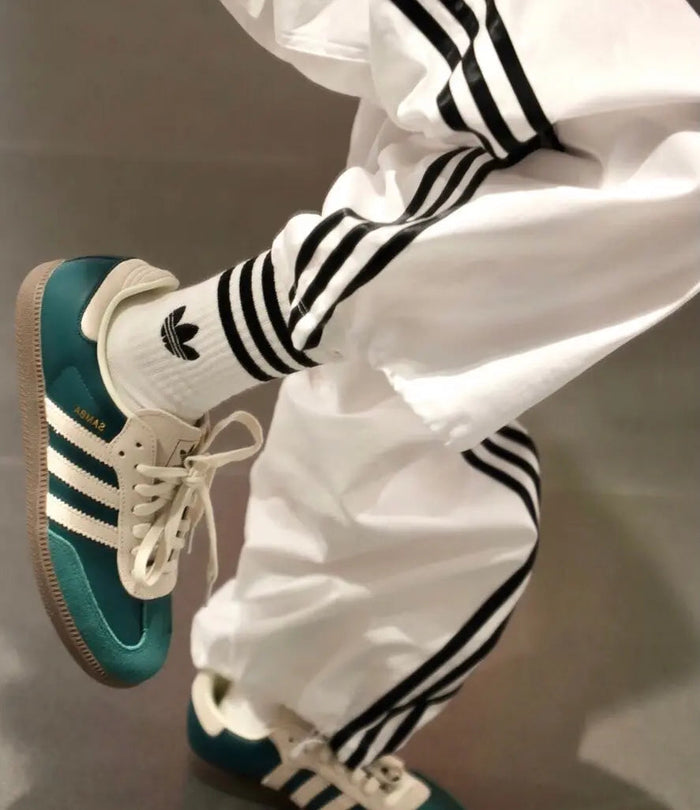Adidas Samba OG sneakers with white laces and green suede, worn with white pants
