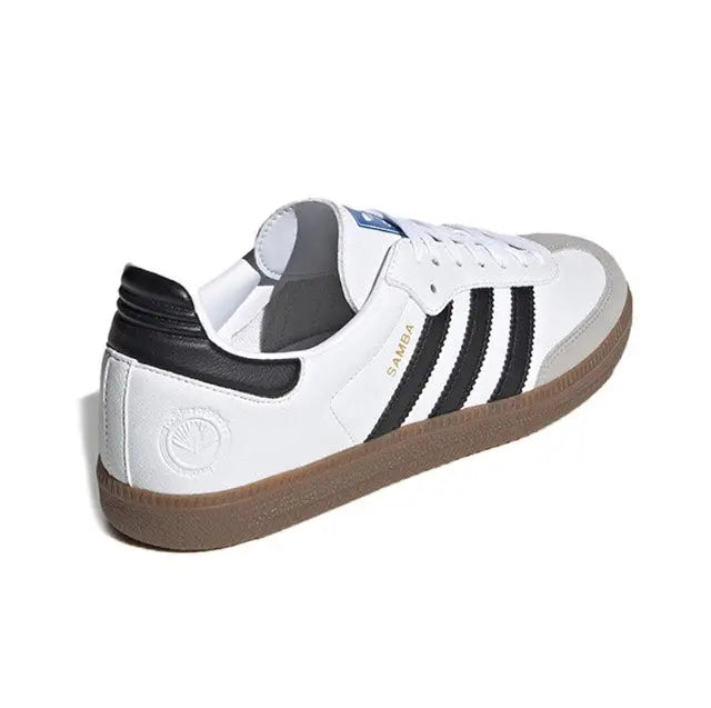 White Adidas Samba vegan sneakers with black heel tab, side stripes, and gum sole.