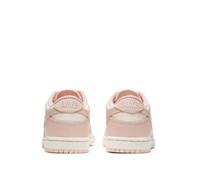 Light pink Nike SB Dunk Low sneakers from the heel and back; visible heel branding.