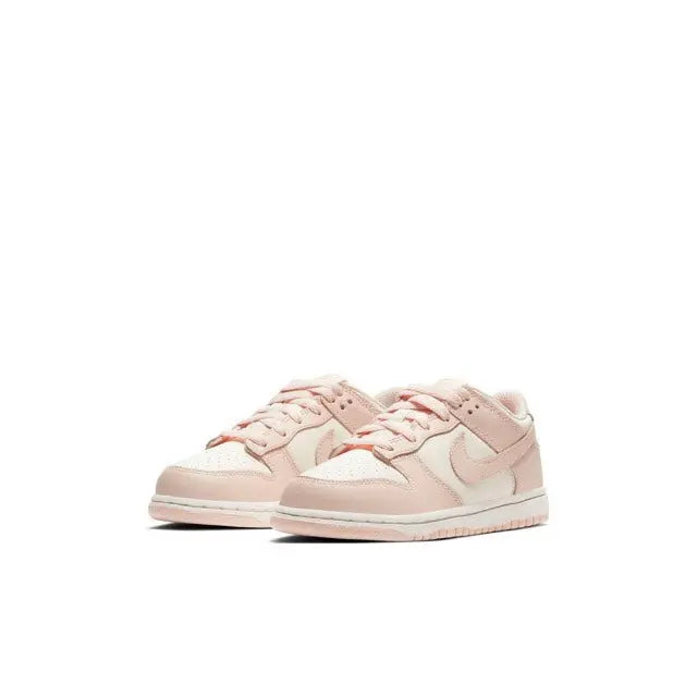 Light pink Nike SB Dunk Low sneakers in a front angled view, lace-up with white swoosh.