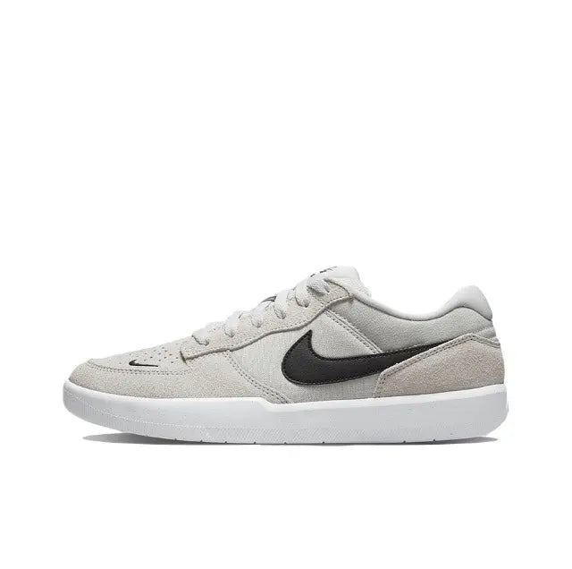 Grey low-top Nike SB skate shoe with black swoosh and white rubber sole