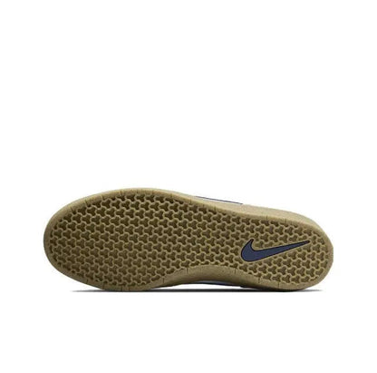 Low-top sneaker outsole view with navy logo on textured gum rubber tread