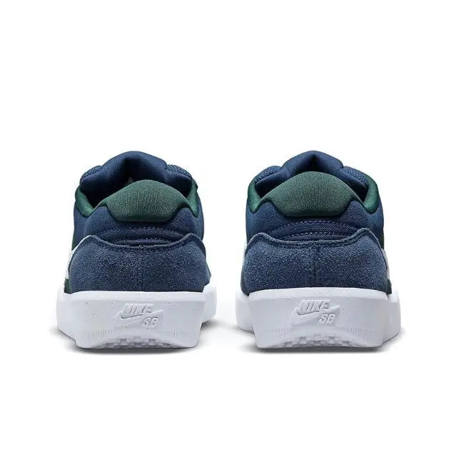 Navy skate shoes with green heel lining and white midsole back logo