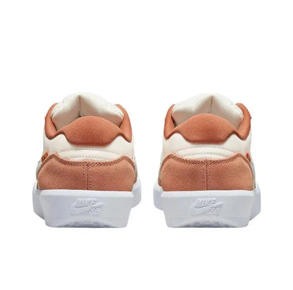 Nike SB low-top sneaker heel view with rust suede overlays and padded cream collar.