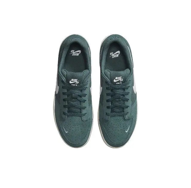 Green low-top sneakers pair with lace-up eyelets, Nike branding on tongue