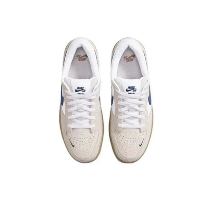 Low-top sneaker front view with white laces, perforated toe, and navy accents