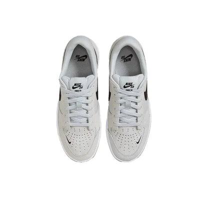 White laced Nike SB sneaker with perforated toe and black side swoosh