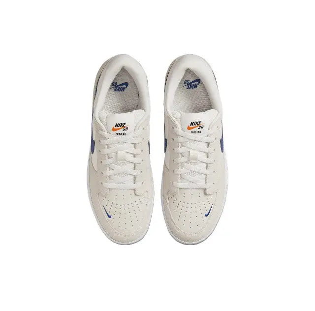 Low-top skate shoes front view, white laces on cream upper with blue accents.
