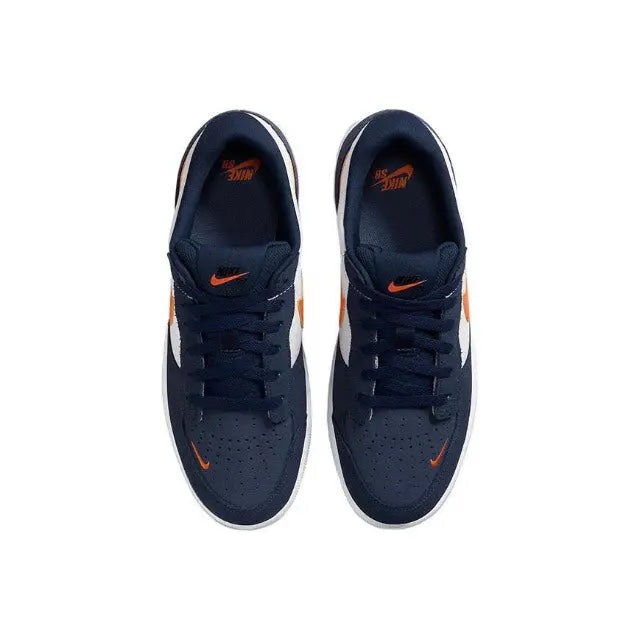 Pair of navy low-top sneakers with orange accent and black lace-up eyelets