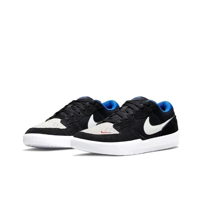 Black low-top skate sneakers with white toe panel, blue accents, and white Swoosh