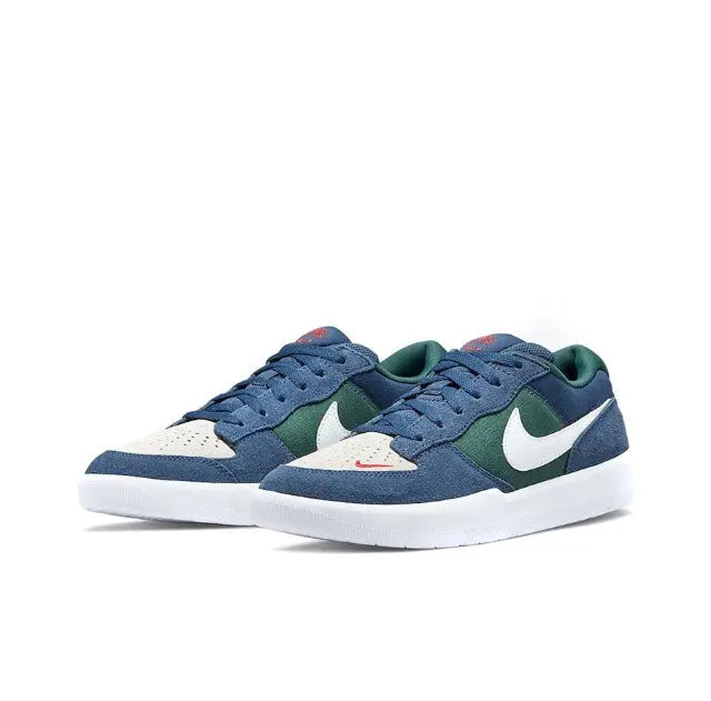 Navy low-top skate shoes with green and white accents, lace-up design