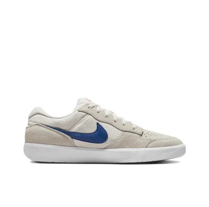 Low-top skate shoes side profile, cream upper with blue Swoosh and lace-up front.