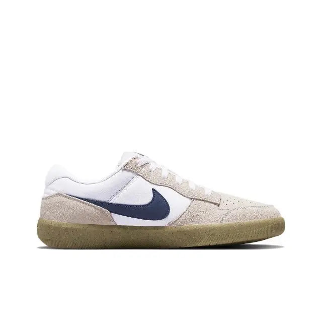 Low-top sneaker side view in white and beige with navy swoosh and gum rubber sole