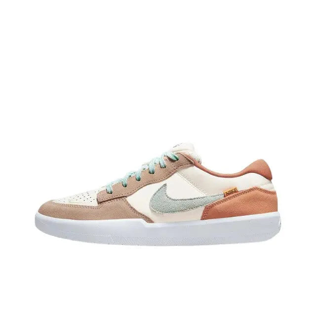 Low-top Nike SB sneaker with cream upper, tan toe, rust heel, and mint swoosh.