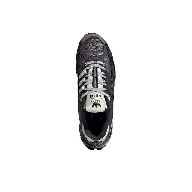 Low-top sneaker with black upper, gray stripe detailing, and white tongue label