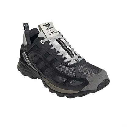 Trail sneaker with black upper, light gray laces, and cushioned dark midsole