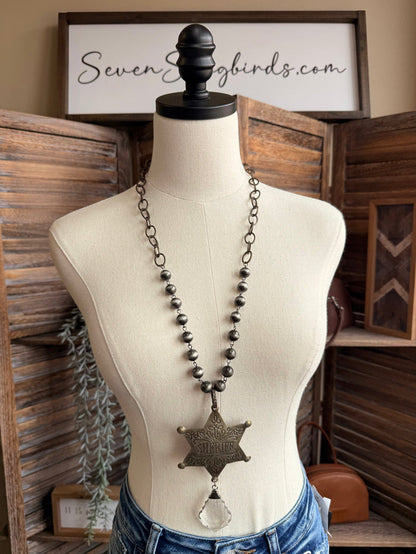 Long dark beaded chain necklace with bronze sheriff star and crystal drop
