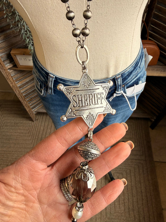 Silver sheriff star pendant necklace with dangling crystal, pearls, and chain