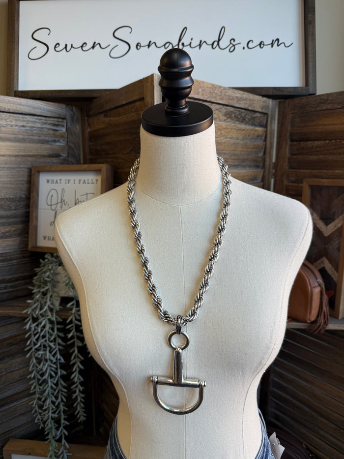 Silver braided chain necklace on mannequin with snaffle bit pendant and ring
