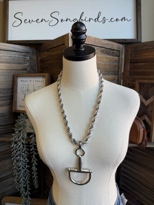 Silver braided chain necklace on mannequin with snaffle bit pendant and ring