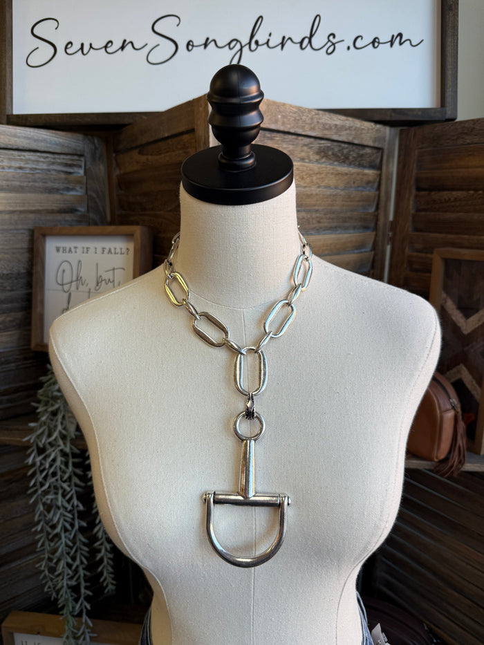 Silver-tone open-link necklace with long hanging U-shaped bit pendant on mannequin