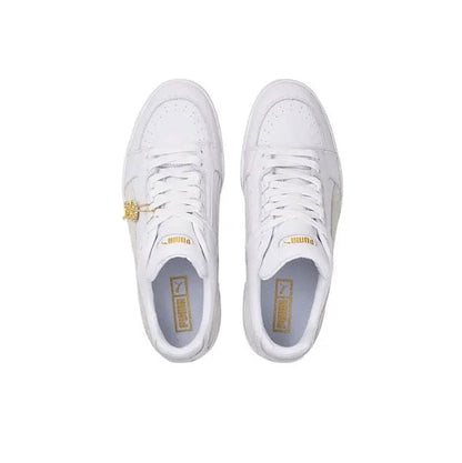 White Puma low-top sneakers, front view, with lace and gold logo detail