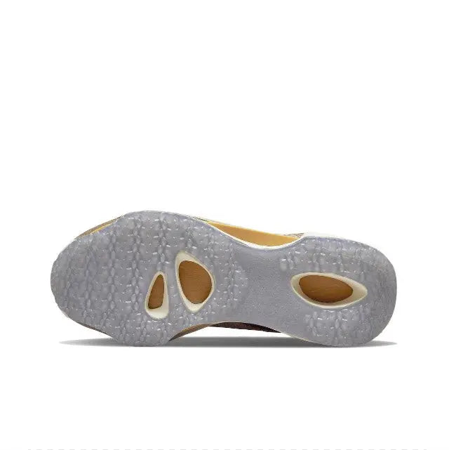 Outsole view of knit running sneaker with textured gray sole and tan cutouts