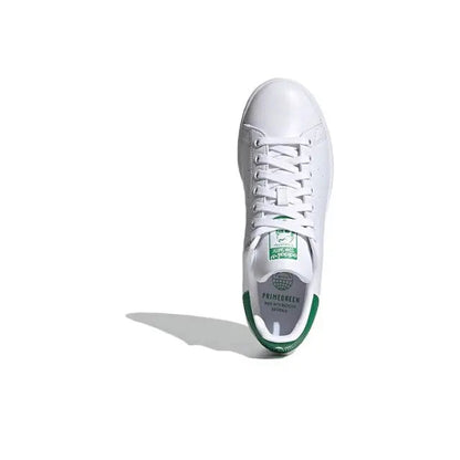 White leather sneakers with green heel lining and lace-up closure