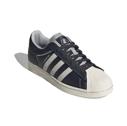 Adidas Superstar low-top sneakers with dark carbon upper and white triple stripes