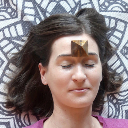Tigers Eye Pyramid placed on woman's third eye