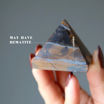 hand holding Tigers Eye Pyramid