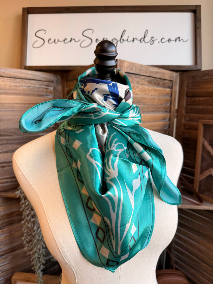 Turquoise wild rag scarf with geometric border and blue-and-white horse graphic, draped