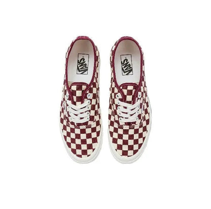 Pair of low-top checkerboard canvas sneakers with white laces and burgundy lining