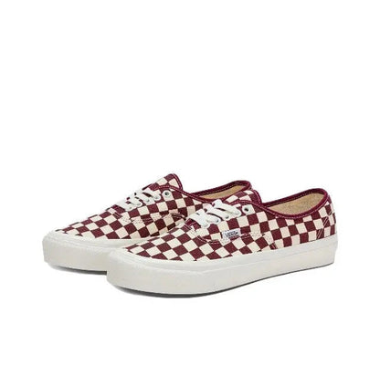 Angled view of low-top checkerboard canvas sneakers with white laces and white sole