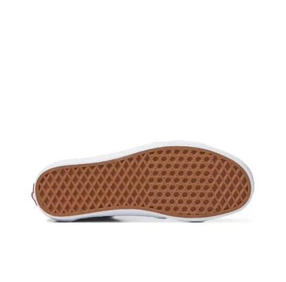 Low-top skate shoe outsole with brown tread, white midsole edge, green side panel