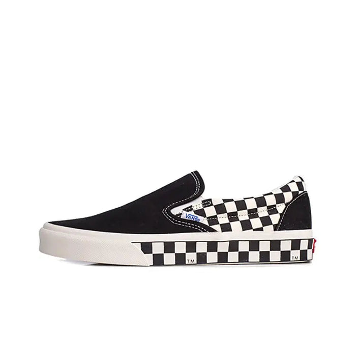 Vans slip-on sneaker in black canvas with checkerboard side stripe and white rubber sole