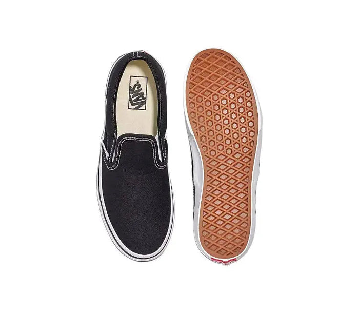 Vans Slip On black canvas sneakers; tan gum outsole and interior lining, pair view.